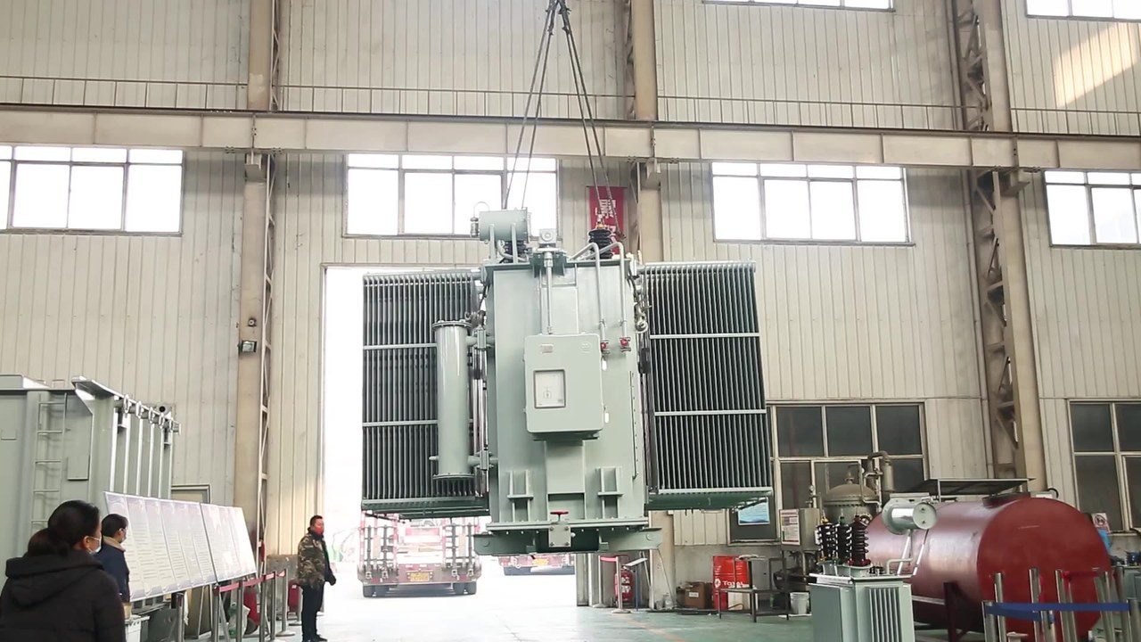 Truck crane lifting a transformer core assembly during on-site installation